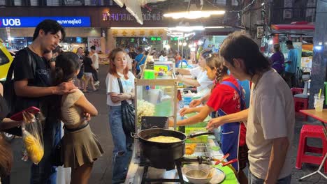Street-food-vendors-selling-food-for-customers-in-the-bustling-Yaowarat-Chinatown,-Bangkok,-Thailand