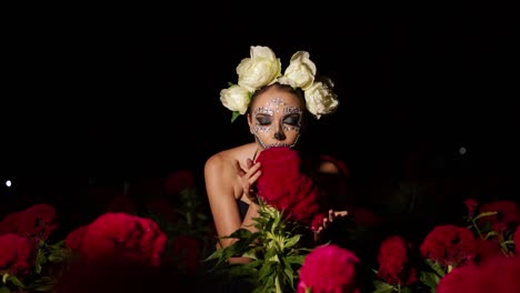 Model-dressed-in-catrina-costume,-modeling-in-the-middle-of-a-velvet-flower-field