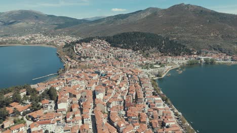 Epischer-Drohnenflug-über-Einem-Historischen-Dorf-Auf-Einem-Hügel-In-Europa,-Rote-Dächer,-Kleine-Häuser,-Sonniges-Wetter,-Blauer-See,-Malerische-Berge,-Griechenland-4K-Video