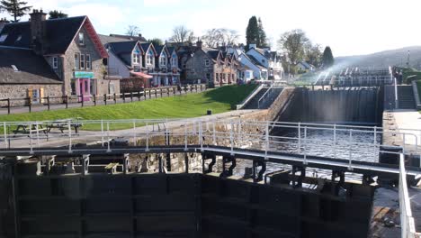 View-of-popular-tourism-destination-of-Fort-Augustus-with-Caledonian-Canal,-locks,-and-local-shops-and-cafes-in-the-highlands-of-Scotland-UK