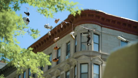 Shoes-Hanging-on-Wire-in-Front-of-Harlem-Apartment-Building,-New-York-City