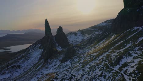 Cinematic-backward-flight-from-the-Old-Man-of-Storr-reveals-snow-dusted-Scottish-Highlands