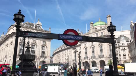 Amidst-a-sunlit-day-in-London,-England,-people-traverse-the-entrance-of-Piccadilly-Circus-Underground-Station