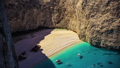 Iconic-Navagio-beach-with-rusty-shipwreck-and-arriving-boats-in-Zakynthos,-time-lapse-view