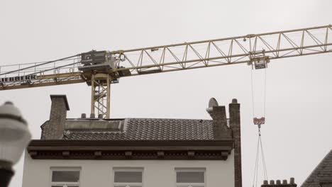 Baukran-Im-Einsatz-über-Den-Dächern-Städtischer-Gebäude