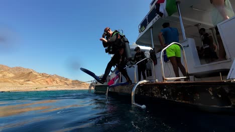 A-Scuba-Diver-Plunging-Into-the-Water-From-the-Boat-in-Dahab,-Sinai-Peninsula,-Egypt---Slow-Motion