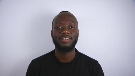 Black-Male-Slowly-Looking-Up-And-Smiling-To-Camera-With-White-Background