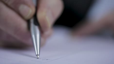 Close-up-of-a-hand-writing-with-a-pen-on-paper-in-soft-focus