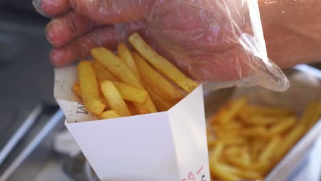 A-chief-put-french-fries-in-a-packet,-close-up-shot,-insert-shot