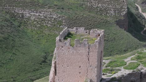 Vuelo-Orbital-Con-Dron-Sobre-El-Castillo-De-Oreja-Del-Siglo-IX,-Creando-Un-Efecto-Visual-Espectacular-Al-Filmar-En-70-Mm-Con-Un-Fondo-De-Campos-Salvajes-Y-Una-Magnífica-Ubicación-De-La-Fortaleza.