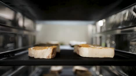 Close-up-of-grilled-pork-belly-slices-in-an-oven,-showcasing-sizzling-and-delicious-details