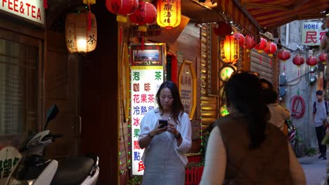 Familia-Tomando-Fotos-En-El-Estrecho-Callejón-De-La-Antigua-Calle-Jiufen-Con-Faroles-Rojos-Iluminados-A-Lo-Largo-Del-Callejón,-Una-Atracción-Turística-Popular-En-Taiwán