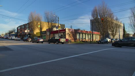 Buses-and-cars-moving-along-the-streets-in-East-Vancouver,-British-Columbia,-Canada---Wide-Shot