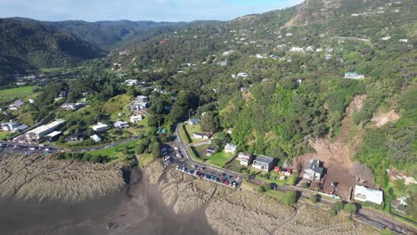 Aerial-View-Of-Piha-Beach-And-Coastal-Settlement-In-West-Auckland,-New-Zealand