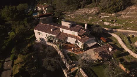 A-luxurious-house-with-terracotta-roofs-on-the-french-riviera,-surrounded-by-nature,-aerial-view