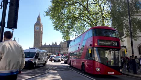 Sunny-day-at-Parliament-Square-Garden,-red-double-decker-bus-and-busy-street-traffic