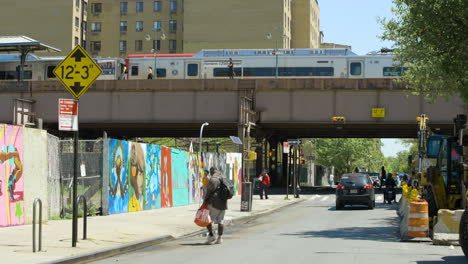 Zug-Verlässt-Harlem-125th-Street-Station,-Während-Menschen-Die-Straße-Darunter-Entlang-Gehen