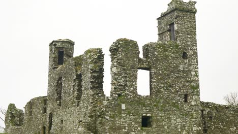 Old-ruins-of-the-medieval-Hill-of-Slane-with-stone-towers-against-a-cloudy-sky-in-County-Meath,-Ireland