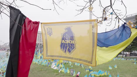 Azov-flag-hangs-next-to-Ukranian-flag-across-tree-branches-in-capitol-city-of-Kyiv