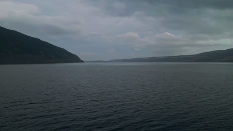 Low-flight-over-the-waters-of-Loch-Ness-in-the-Scottish-Highlands,-dolly-in-movement