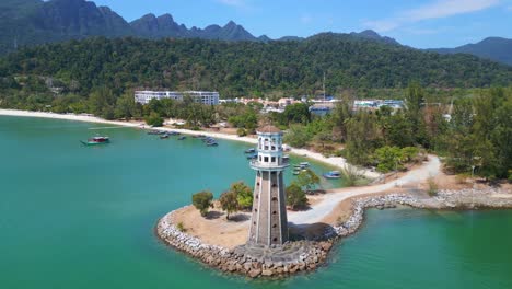 Solitary-lighthouse-on-headland-with-scenic-tropical-beach