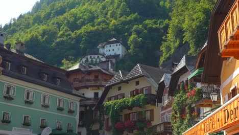 Un-Joven-Camina-En-Un-Balcón-De-Una-De-Las-Casas-Del-Pueblo-De-Hallstatt.