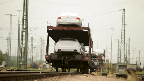 Neue-Autos-Auf-Einen-Zug-Für-Den-Transport-Geladen,-Aufgenommen-An-Einem-Bewölkten-Tag-Auf-Einem-Güterbahnhof