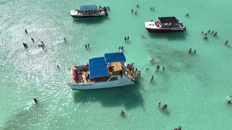 Touristen-Schwimmen-Im-Türkisfarbenen-Meer-Neben-Ihrem-Ausflugsboot-In-Der-Dominikanischen-Republik