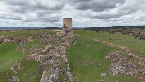 Vista-Aérea-Hacia-Atrás-De-Una-Aislada-Torre-De-Vigilancia-Medieval-En-Burgo-De-Osma,-Soria,-España,-En-La-Cima-De-Una-Colina.