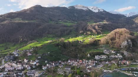 Aerial-view-of-Walensee,-Weesen,-Switzerland-showing-quaint-village-and-snow-capped-mountains