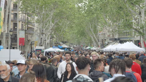 Crowded-street-scene-on-La-Rambla,-Barcelona-with-diverse-pedestrians-and-canopy-trees