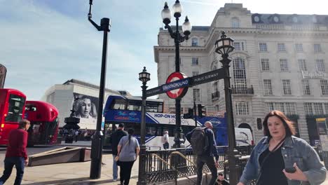 Sonniger-Morgenblick-Auf-Piccadilly-Circus,-Ausfahrt-3-Mit-Verkehr-Und-Vorbeifahrenden-Fußgängern