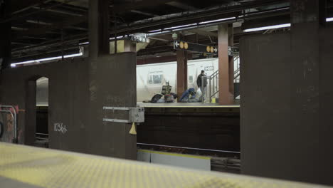 Man-Hands-Homeless-Woman-Money-on-New-York-City-Subway-Platform