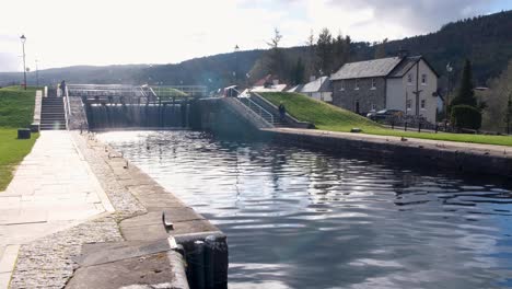 Early-morning-soft-light-shimmering-over-Caledonian-Canal-in-the-settlement-of-Fort-Augustus,-highlands-of-Scotland-UK