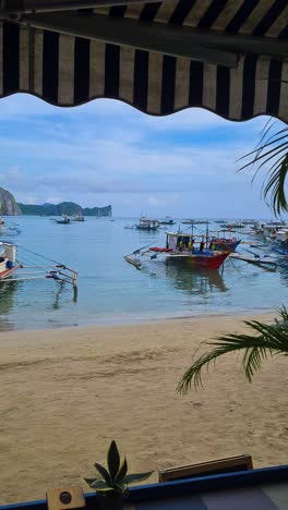 Vídeo-Vertical,-El-Nido-Filipinas,-Barcos-De-Playa-Y-Balangay,-Vista-Panorámica-Desde-El-Restaurante-Frente-A-La-Playa