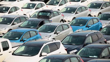 Vast-car-park-filled-with-new-vehicles-in-various-colors-under-bright-sunlight