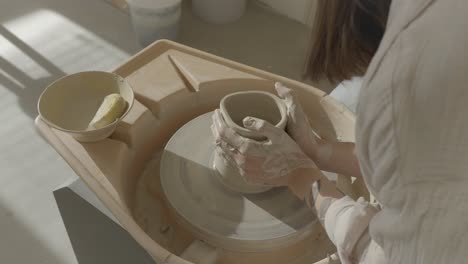 a-female-doing-pottery-on-the-wheel