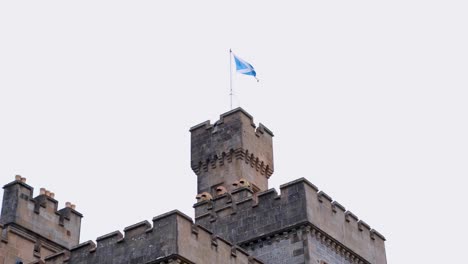 Cerca-De-La-Bandera-Escocesa-Ondeando-En-La-Cima-Del-Castillo-De-Lews-En-Stornoway,-Hébridas-Exteriores-De-Escocia,-Reino-Unido