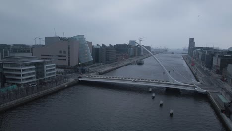 Dublin-city-center-featuring-the-iconic-harp-bridge-and-convention-centre,-cloudy-day,-aerial-view