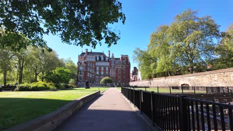 POV-Walking-Past-Railings-Along-Abingdon-Gardens-In-Westminster-With-Millbank-House-In-Background-On-Sunny-Morning