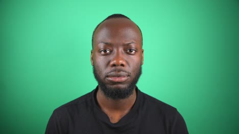 Black-Male-Staring-To-Camera-With-Blank-Face-With-Green-Screen-Background