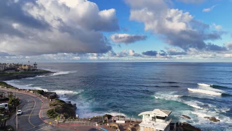 Vuelo-De-Drones-De-La-Jolla-Cove-Hacia-Atrás-Que-Revela-Una-Piscina-Para-Niños-Con-Luz-De-La-Mañana-Y-Nubes-Dramáticas-Sobre-El-Océano