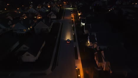 Car-driving-through-dark-American-neighborhood-at-night