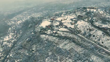 High-angle-drone-shot-of-snow-covered-Karimabad-city-in-Hunza,-Pakistan