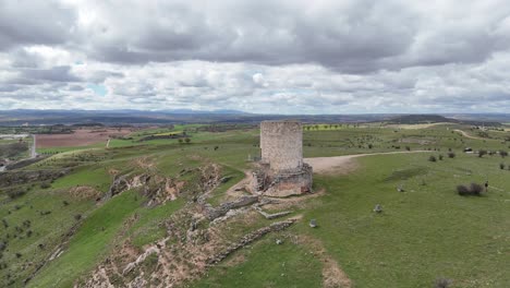 Aerial-dron-spinning-flight-of-an-isolated-medieval-watch-tower-in-Burgo-de-Osma,-Soria,-Spain