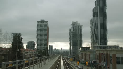 Traveling-On-Elevated-Railway-In-The-City-With-High-Rise-Buildings-In-Vancouver,-British-Columbia,-Canada