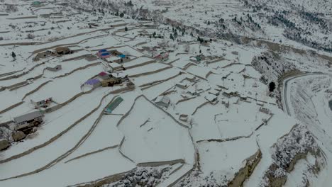 Aerial-View-Of-Snow-Covered-Rural-Village-Farmland-In-Naltar-Valley,-Gilgit