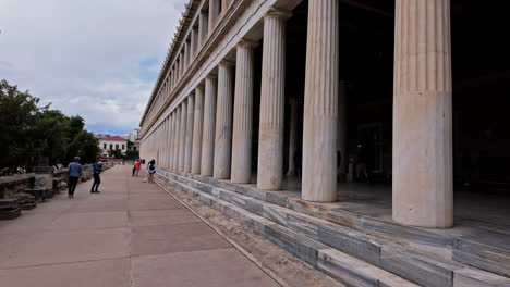 Slow-motion-shot-of-tourists-walking-around-Stoa-of-Attalos-in-Agora,-Athens,-Greece-at-daytime