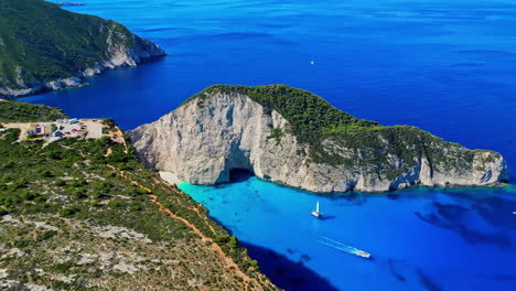 Aerial-pan-reveals-white-sandy-Navagio-beach-with-vibrant-blue-ocean-water,-Greece