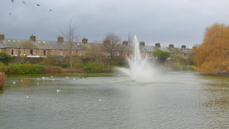 Profile-view-of-Blessington-Street-Basin-with-fountain-on-pond-in-Dublin,-Ireland